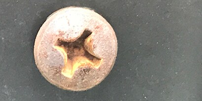 Hapettumista, ruostetta ja galvaanista korroosiota metalliruuvin kannassa

