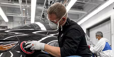 Kuva, jossa mies käyttää premium-hiomatuotteita ja premium-työkaluja autossa saavuttaakseen erinomaisia tuloksia.
